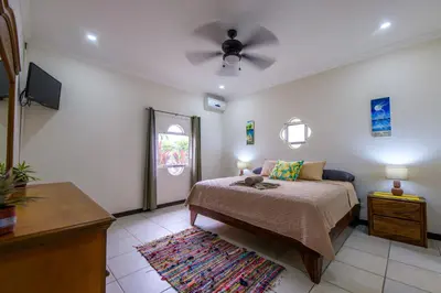 a bedroom with a bed and a ceiling fan at Villa Sirena Del Mar by Vacation Pura Vida in Bejuco