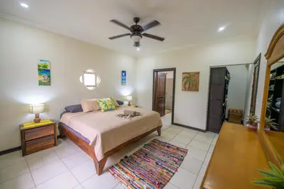 a bedroom with a bed and a ceiling fan at Villa Sirena Del Mar by Vacation Pura Vida in Bejuco