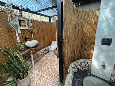 a bathroom with a toilet and a wooden fence at La VanDida, Camper house in Paraíso