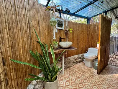 a bathroom with a toilet and a wooden fence at La VanDida, Camper house in Paraíso