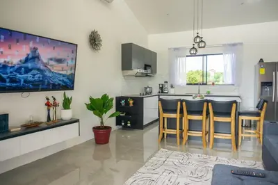 a living room with a kitchen with a bar at Verde Armonía Lodge in Naranjito