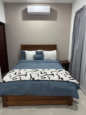 a bedroom with a bed with a black and white comforter at Verde Armonía Lodge in Naranjito