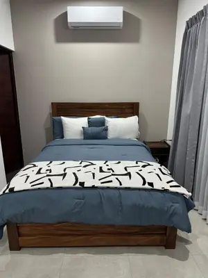a bedroom with a bed with a black and white comforter at Verde Armonía Lodge in Naranjito