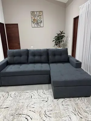 a blue sectional couch in a living room at Verde Armonía Lodge in Naranjito