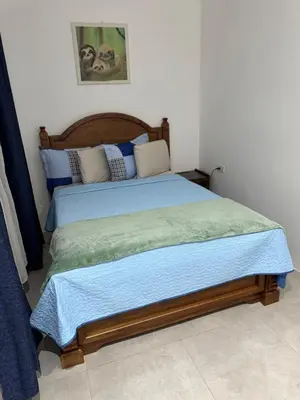 a bedroom with a bed with a blue comforter at Verde Armonía Lodge in Naranjito