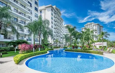 a large swimming pool in front of a building at Primium Jaco Bay in Jacó