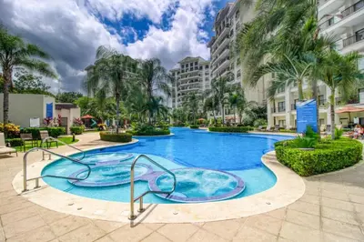 a swimming pool at a resort with a slide at Primium Jaco Bay in Jacó