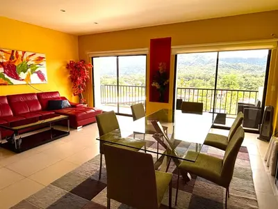 a living room with a table and a red couch at Primium Jaco Bay in Jacó