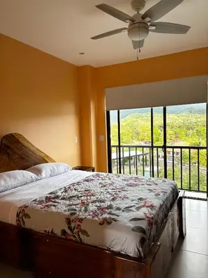 a bedroom with a bed and a large window at Primium Jaco Bay in Jacó