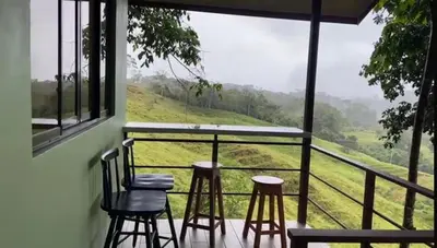 a balcony with stools and a view of a field at Casita El Perezoso in San Rafael