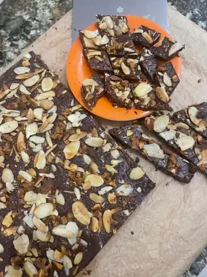 a plate of chocolate and nuts on a cutting board at Susanne's Bungalow de Casa Felicidad in Paquera