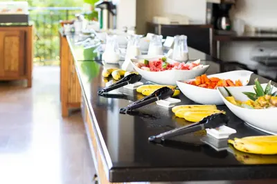 a buffet line with bowls of fruits and vegetables at Bodhi Tree Yoga Resort in Nosara