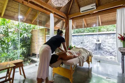 a woman giving a man a massage in a room at Bodhi Tree Yoga Resort in Nosara
