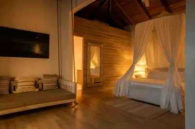 a bedroom with a canopy bed and a couch at Bodhi Tree Yoga Resort in Nosara