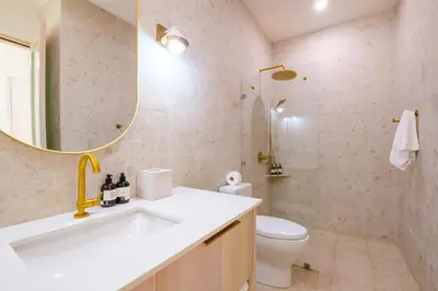 a bathroom with a sink and a toilet and a mirror at Bodhi Tree Yoga Resort in Nosara
