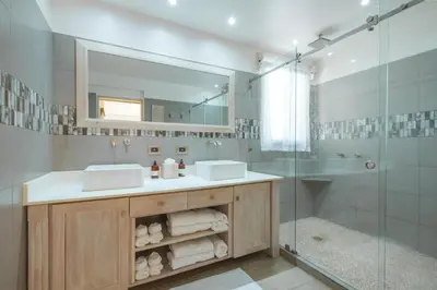 a bathroom with two sinks and a glass shower at Bodhi Tree Yoga Resort in Nosara