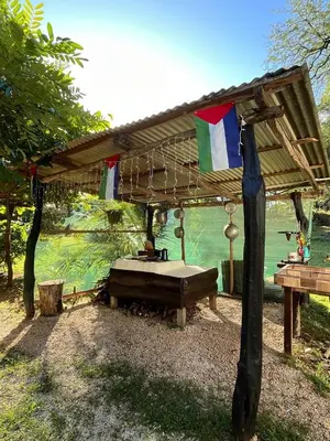 a wooden pergola with a bed and a table at Villa Rancho Caballito in Nicoya