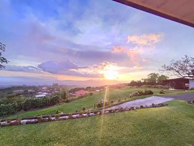 a view of the sunset from the backyard of a house at Hospedaje con relajante Vista in Grecia