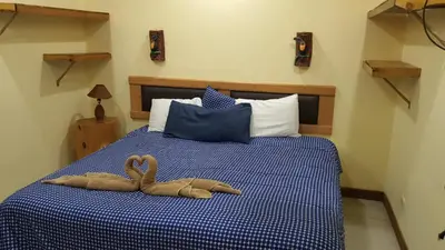 a bedroom with a bed with two swans on it at Hotel Orocay Lodge in Cartago