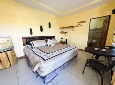 a bedroom with a bed and a table and a shower at Hotel Orocay Lodge in Cartago
