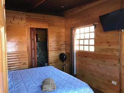 a bedroom with a bed in a log cabin at Hotel Orocay Lodge in Cartago