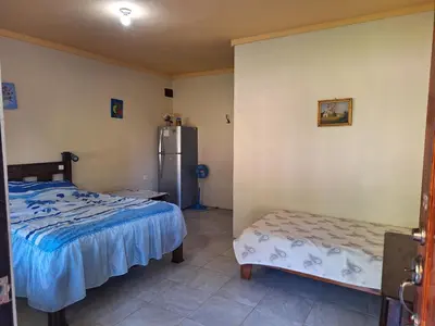 a bedroom with two beds and a refrigerator at La Tica in Horquetas