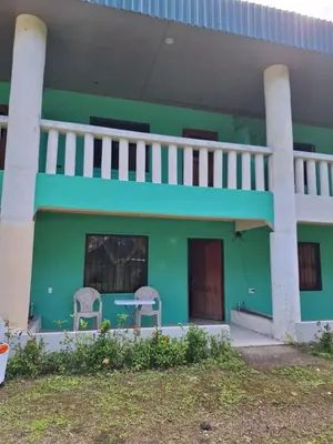 a green house with two chairs in front of it at La-Tica in Horquetas