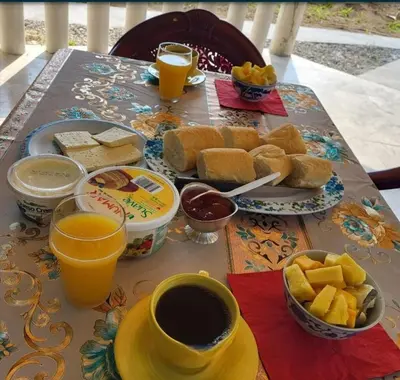 a table with a breakfast of bread and coffee and orange juice at La-Tica in Horquetas