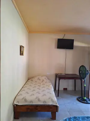 a small bedroom with a bed and a desk at La-Tica in Horquetas