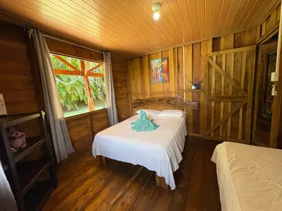 a bedroom with two beds and a window at Cabaña YeyYe in San Ramón