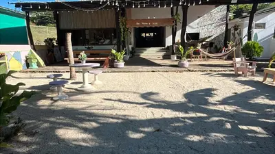 a patio with tables and chairs in front of a building at Tsunami Hostel in Tamarindo