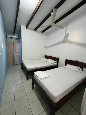 a room with two beds and a ceiling at Tsunami Hostel in Tamarindo