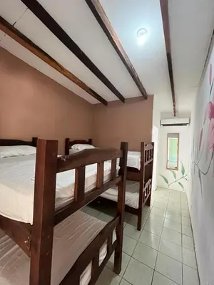 a room with three bunk beds in it at Tsunami Hostel in Tamarindo