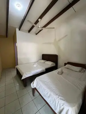 a room with two beds and a ceiling at Tsunami Hostel in Tamarindo