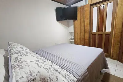 a bedroom with a bed and a tv on the wall at The Hideaway La Fortuna in Fortuna