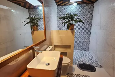 a bathroom with a sink and a toilet and a mirror at The Hideaway La Fortuna in Fortuna