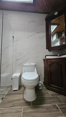 a bathroom with a toilet and a sink and a mirror at The Hideaway La Fortuna in Fortuna
