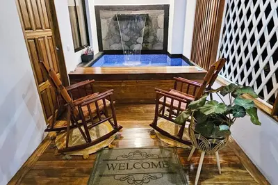 a porch with two chairs and a plunge pool at The Hideaway La Fortuna in Fortuna