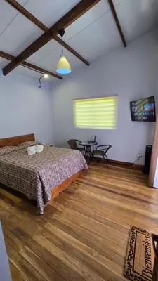 a bedroom with a bed and a table in it at Bahia Ballena Walk to the Beach Uvita Apartments in Uvita