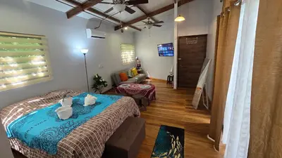 a bedroom with a bed and a living room at Bahia Ballena Walk to the Beach Uvita Apartments in Uvita