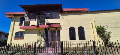 a church with a fence in front of a building at Hostal Zurgab in San Vicente