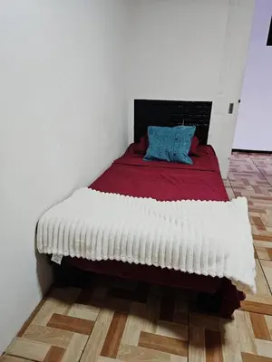 a bedroom with a bed with a red and white blanket at Hostal Zurgab in San Vicente
