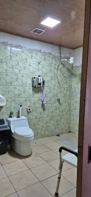 a bathroom with a toilet and a stone wall at Hostal Zurgab in San Vicente