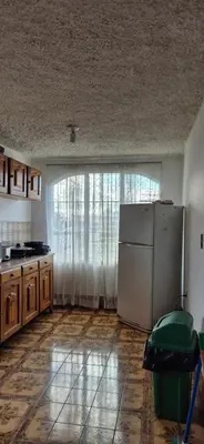 a kitchen with a white refrigerator and a window at Hostal Zurgab in San Vicente
