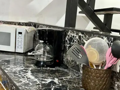 a kitchen counter with a blender and a microwave at Apartamento Chazu #3 in Quepos