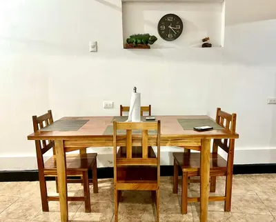 a dining room table with chairs and a clock on the wall at Apartamento Chazu #3 in Quepos