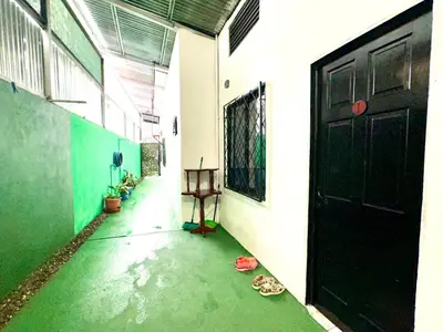an empty hallway with a black door and a green floor at Apartamento Chazu #3 in Quepos