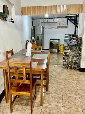 a kitchen with a wooden table and chairs in a room at Apartamento Chazu #3 in Quepos