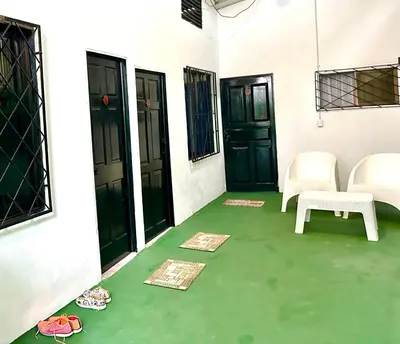 a room with a green floor and black doors at Cabina Chazu#1 in Quepos