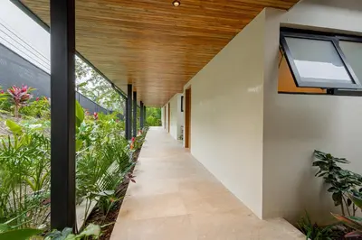 an internal corridor of a house with windows and plants at Bahia Rooms in Mal País